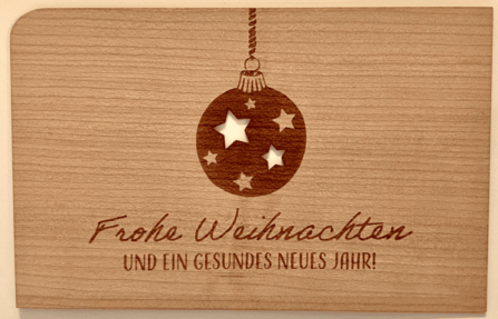 Weihnachtskarte aus Holz mit Weihnachtskugel mit Sternen